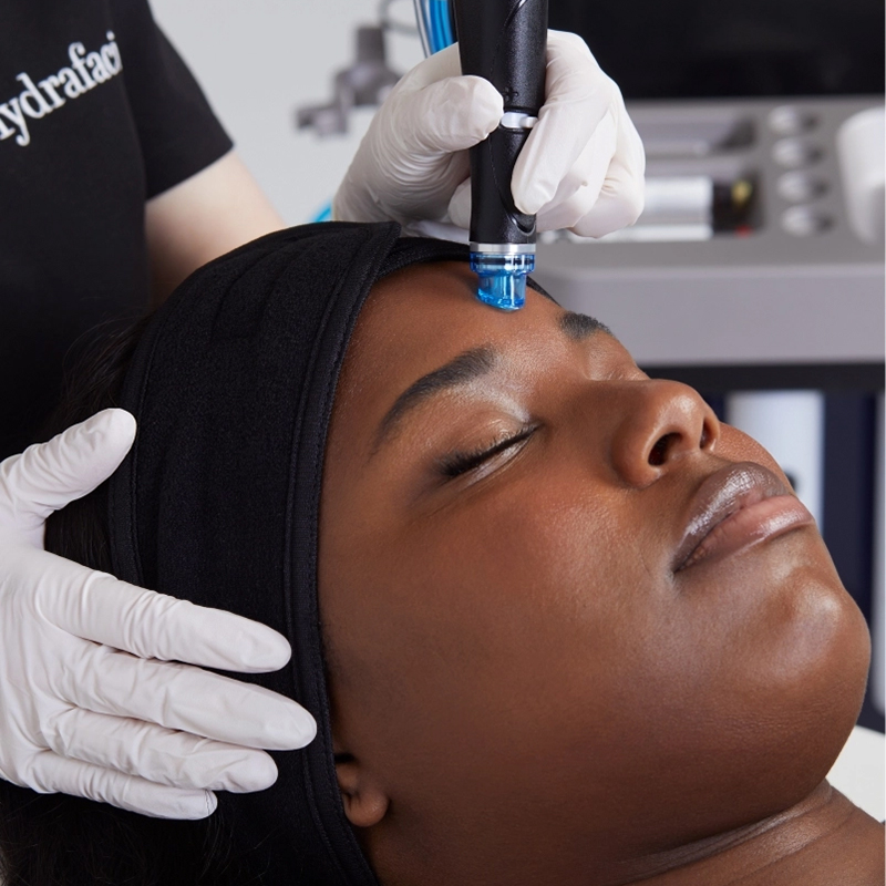 Technician operating Hydrafacial device on woman